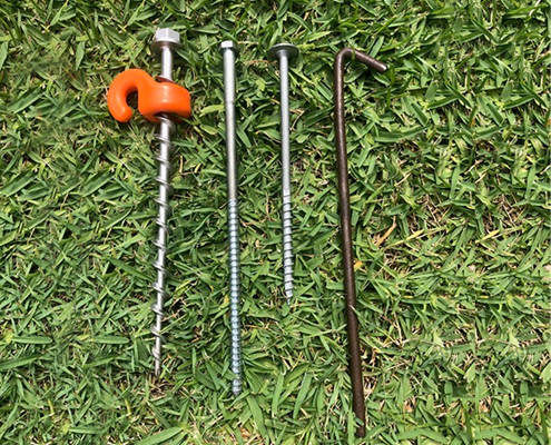 Different types of Screw-in Peg kept on grass ground